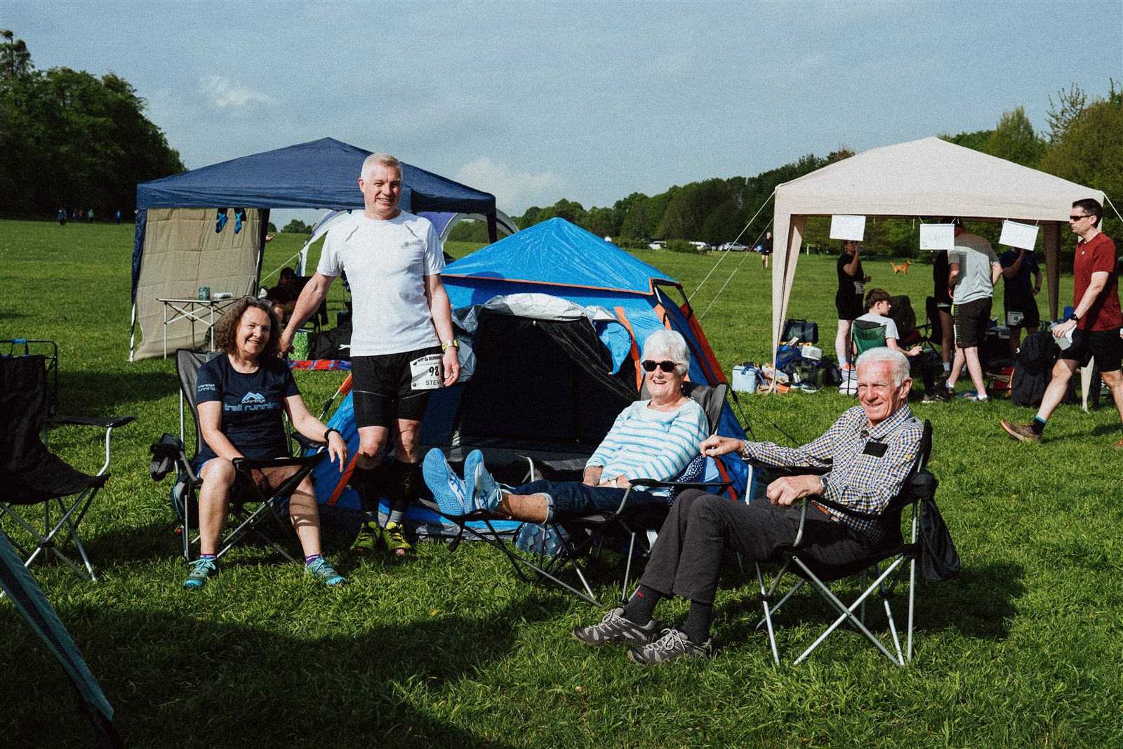 Runner and supporters relaxing beside tents at the Bristol Backyard Ultra basecamp.